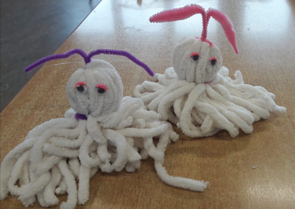 Zwei krakenähnliche, aus Wolle gebastelte Monster 