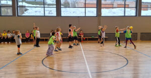 Kinder spielen in der Turnhalle Handball